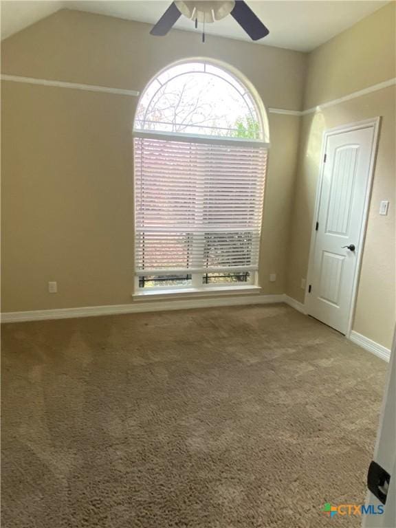 carpeted spare room featuring ceiling fan and lofted ceiling