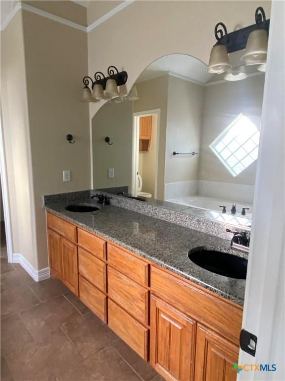 bathroom with tile patterned flooring, vanity, a tub to relax in, and crown molding