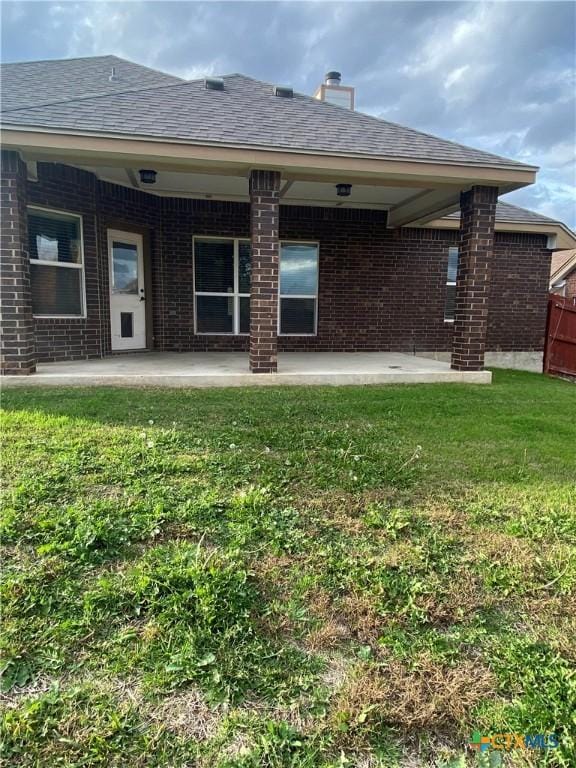 rear view of property with a lawn and a patio