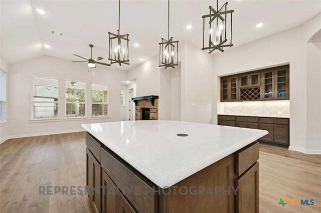 kitchen with light wood finished floors, open floor plan, and tasteful backsplash