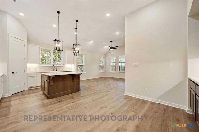 kitchen with light wood-style flooring, a kitchen island, and light countertops