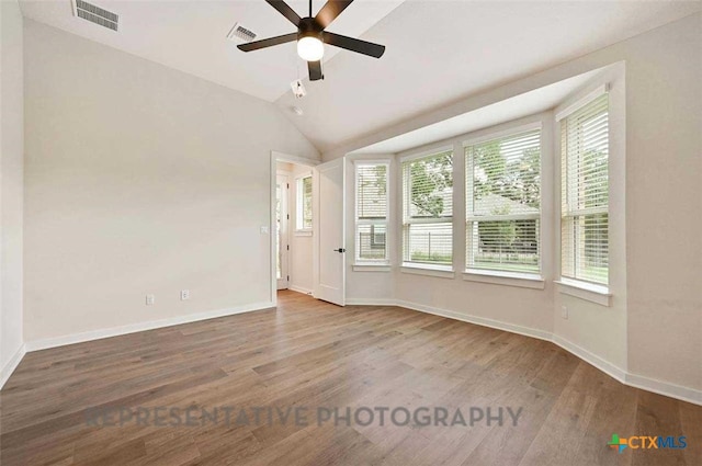 spare room with visible vents, ceiling fan, wood finished floors, and plenty of natural light