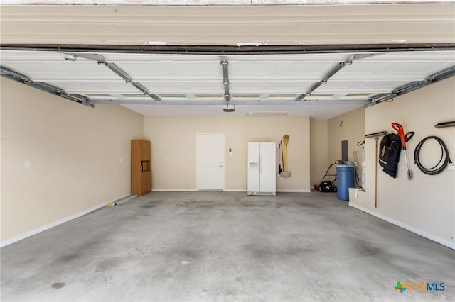 garage featuring baseboards, a garage door opener, and white refrigerator with ice dispenser