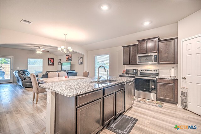 kitchen featuring dark brown cabinetry, sink, appliances with stainless steel finishes, an island with sink, and pendant lighting