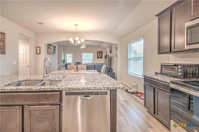3154 Wigeon Way, Copperas Cove, TX 76522 - kitchen featuring stainless steel appliances, a sink, arched walkways, a chandelier, and light wood-style floors