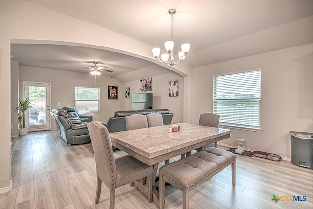 dining room with ceiling fan with notable chandelier, lofted ceiling, and light hardwood / wood-style floors