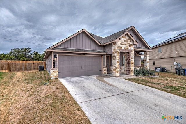 craftsman-style house featuring a garage, central air condition unit, and a front yard