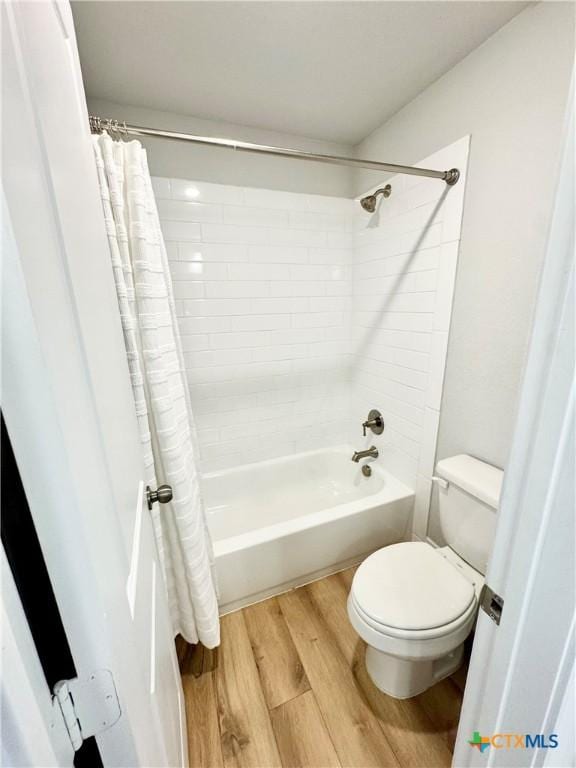 full bathroom featuring shower / bath combination with curtain, wood finished floors, and toilet