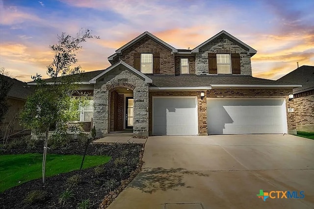 traditional-style house featuring a garage, concrete driveway, and brick siding