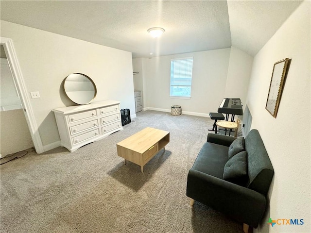 living room with carpet floors, vaulted ceiling, a textured ceiling, and baseboards