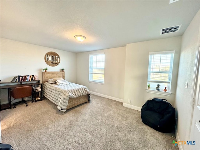 bedroom featuring carpet floors, visible vents, and baseboards