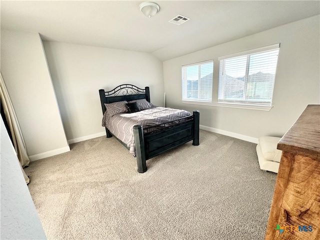 bedroom with vaulted ceiling, carpet flooring, visible vents, and baseboards