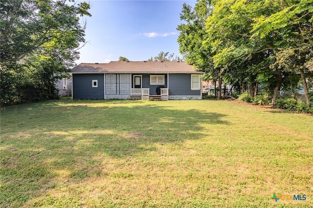 rear view of property featuring a lawn