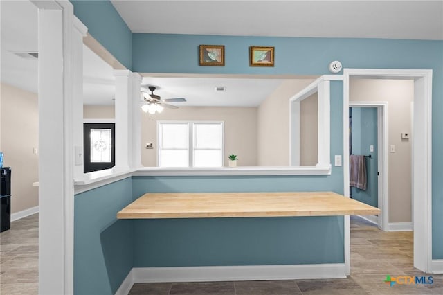 hallway with visible vents, baseboards, and decorative columns