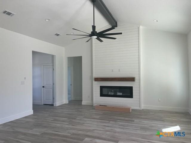 unfurnished living room with lofted ceiling with beams, ceiling fan, hardwood / wood-style flooring, and a fireplace