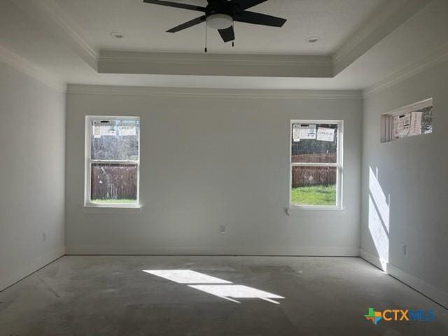 spare room with crown molding, plenty of natural light, and a tray ceiling