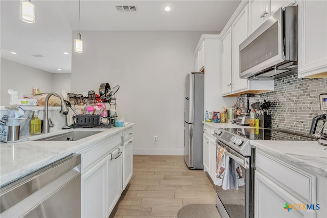 kitchen featuring white cabinets, stainless steel appliances, light hardwood / wood-style floors, and sink