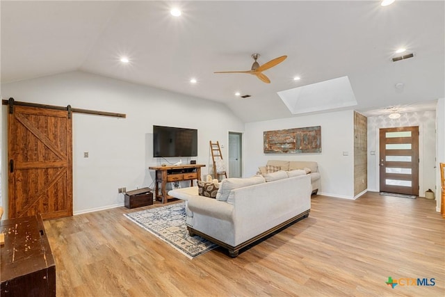 1843 Burr Oak Ln, Adkins, TX 78101 - living area with vaulted ceiling, ceiling fan, light wood-style floors, a barn door, and a skylight