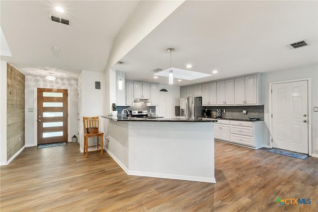 1843 Burr Oak Ln, Adkins, TX 78101 - kitchen featuring stainless steel refrigerator with ice dispenser, dark countertops, a peninsula, light wood finished floors, and recessed lighting