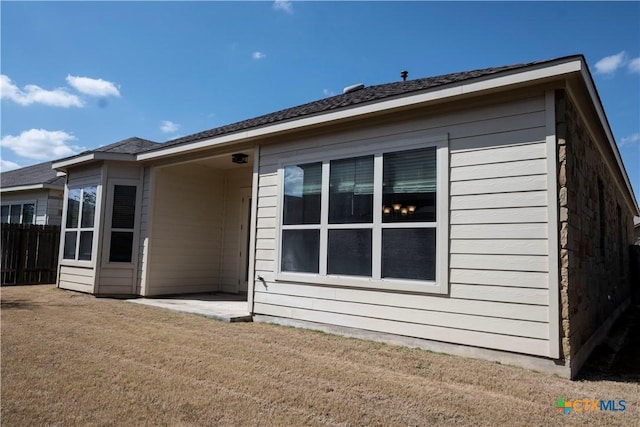 back of house featuring a patio area, fence, and a lawn