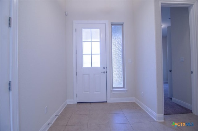 doorway to outside with light tile patterned floors and baseboards