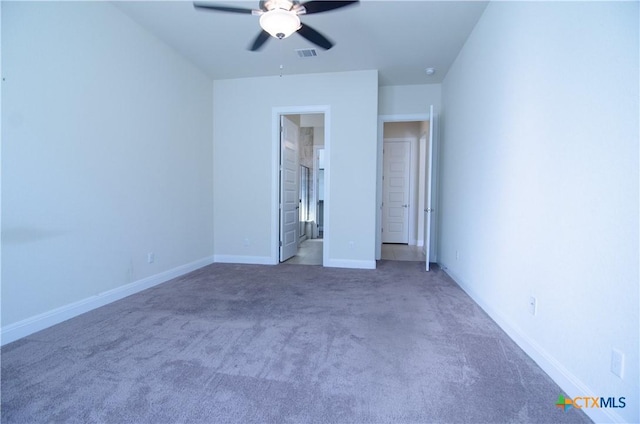 unfurnished bedroom featuring visible vents, baseboards, carpet floors, ensuite bath, and a ceiling fan