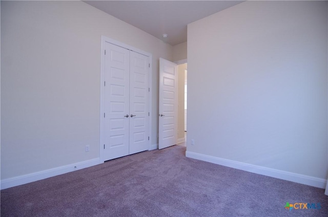 unfurnished bedroom featuring a closet, carpet flooring, and baseboards