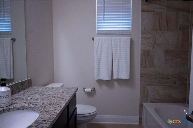 bathroom with vanity, baseboards, a shower, toilet, and a washtub