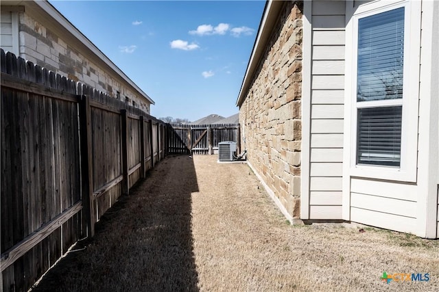 view of yard featuring central air condition unit and fence