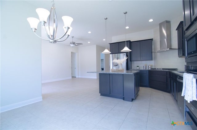 kitchen with light stone counters, a center island, appliances with stainless steel finishes, wall chimney range hood, and decorative backsplash