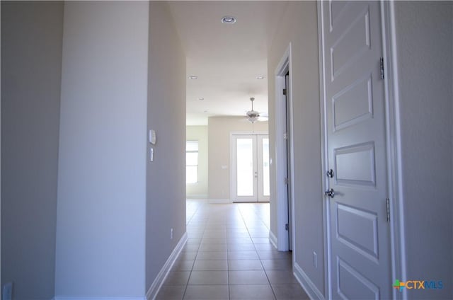 corridor featuring tile patterned floors, recessed lighting, and baseboards