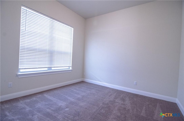 empty room featuring carpet flooring and baseboards