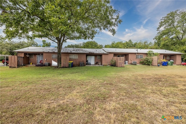 rear view of house with a lawn and central AC unit