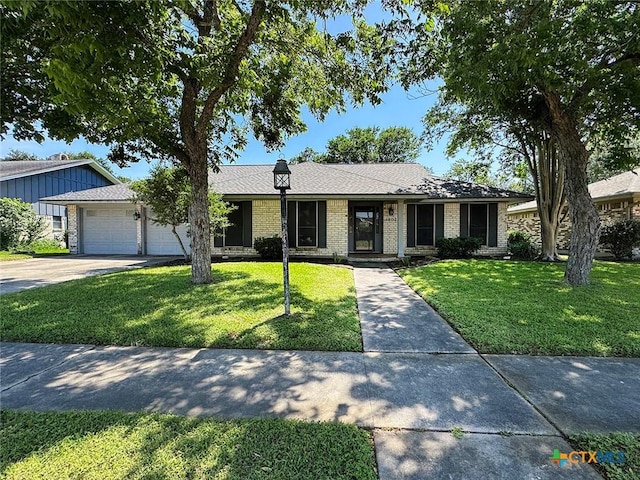 1802 Plantation Rd, Victoria, TX 77904 - single story home with a front yard, an attached garage, concrete driveway, and brick siding
