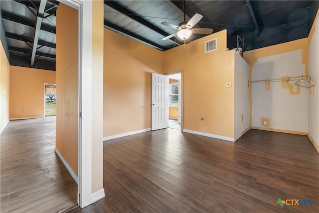 spare room with dark hardwood / wood-style flooring, ceiling fan, and a high ceiling