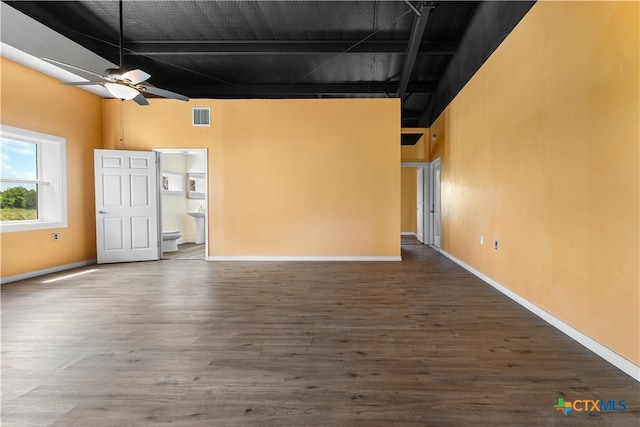 unfurnished living room featuring a high ceiling, ceiling fan, and dark hardwood / wood-style floors