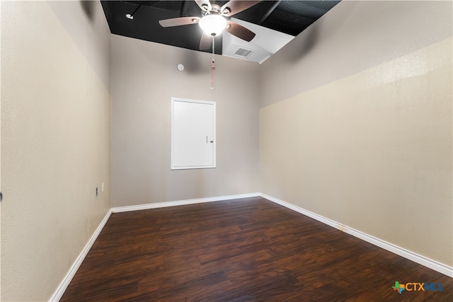 spare room featuring a towering ceiling, ceiling fan, and dark hardwood / wood-style flooring