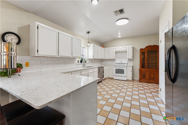 kitchen with black fridge, decorative light fixtures, white range, stainless steel dishwasher, and kitchen peninsula