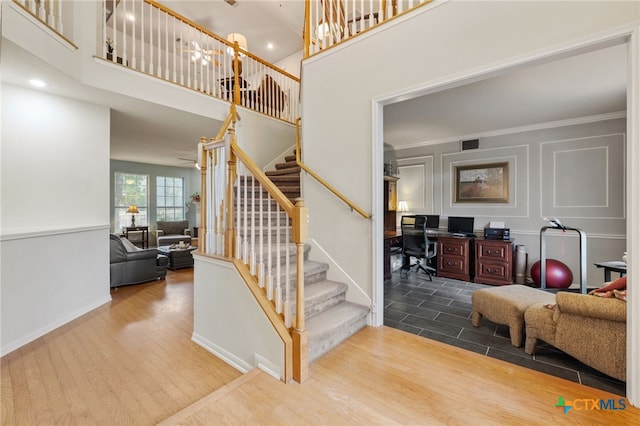 6804 Robert Dixon Dr, Austin, TX 78749 - staircase featuring a high ceiling, baseboards, recessed lighting, a decorative wall, and wood finished floors