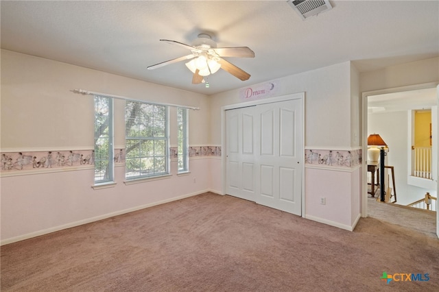 6804 Robert Dixon Dr, Austin, TX 78749 - unfurnished bedroom featuring carpet flooring, a closet, wainscoting, ceiling fan, and baseboards