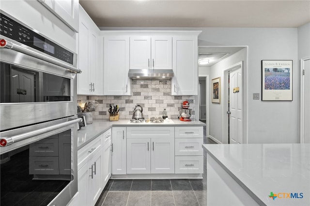 6804 Robert Dixon Dr, Austin, TX 78749 - kitchen featuring stainless steel double oven, decorative backsplash, light countertops, and white cabinets