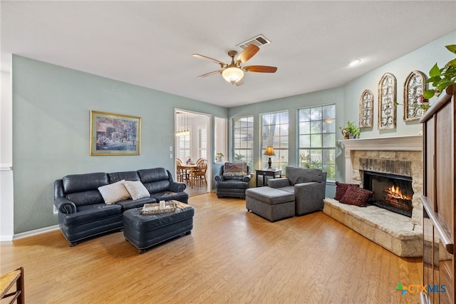 6804 Robert Dixon Dr, Austin, TX 78749 - living area with wood finished floors, a ceiling fan, a lit fireplace, and baseboards