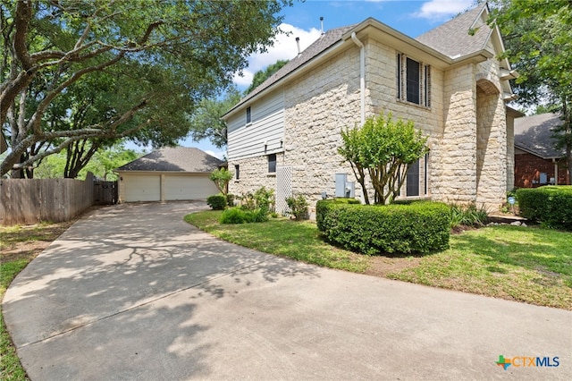 6804 Robert Dixon Dr, Austin, TX 78749 - view of side of home with stone siding, fence, a detached garage, and roof with shingles