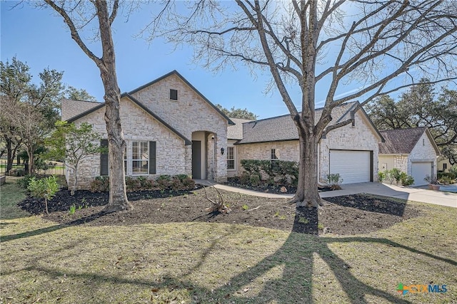 french provincial home featuring a front lawn and a garage