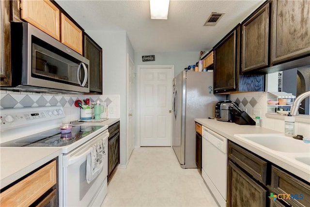 kitchen featuring tasteful backsplash, sink, and white appliances