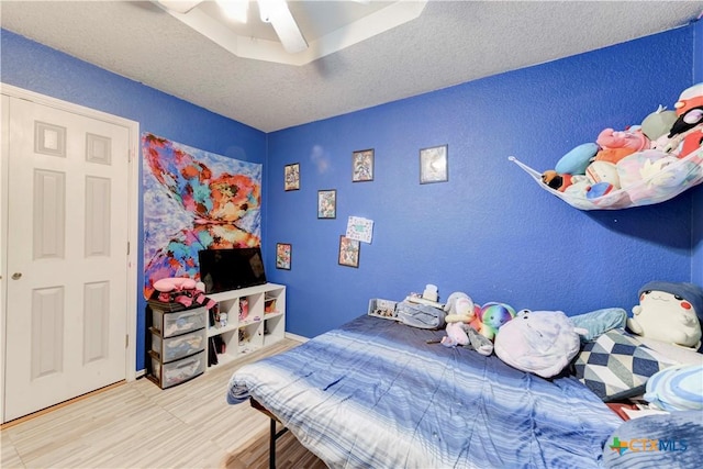 bedroom featuring a textured ceiling, hardwood / wood-style flooring, and ceiling fan