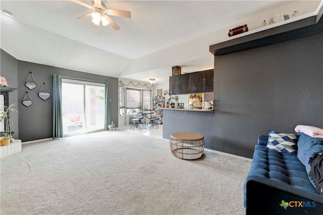 carpeted living room with ceiling fan and lofted ceiling