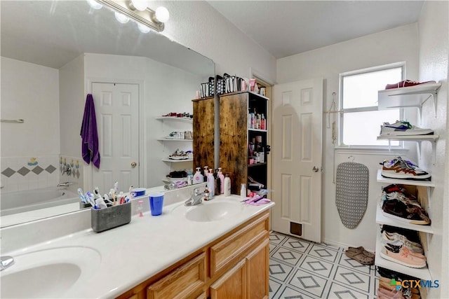 bathroom featuring tile patterned floors, vanity, and a bath