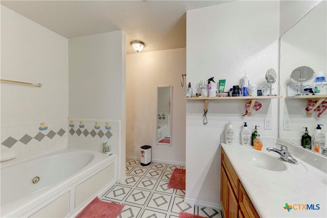 bathroom featuring tile patterned flooring, a washtub, a textured ceiling, and vanity