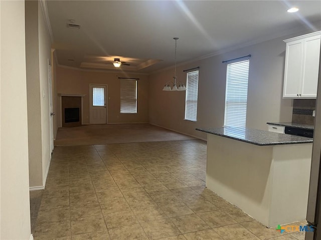 9210 Devonshire Ct, Killeen, TX 76542 - kitchen with crown molding, a tray ceiling, white cabinets, dark stone counters, and hanging light fixtures